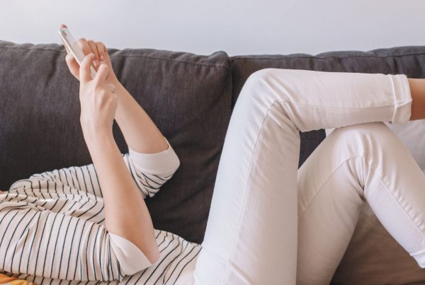 L4 Woman Lying On Couch And Texting Talking At Social Media On Smartphone